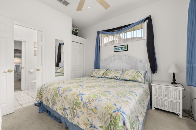 bedroom featuring ceiling fan, ensuite bathroom, a closet, and light tile patterned floors