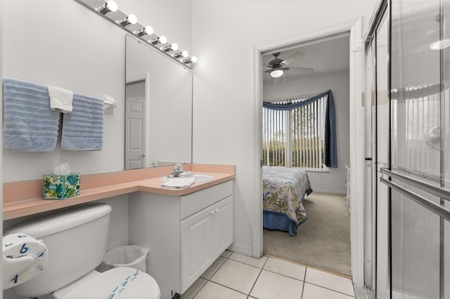 bathroom featuring a shower with door, vanity, tile patterned floors, and toilet