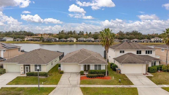 view of front facade featuring a garage, a front lawn, and a water view