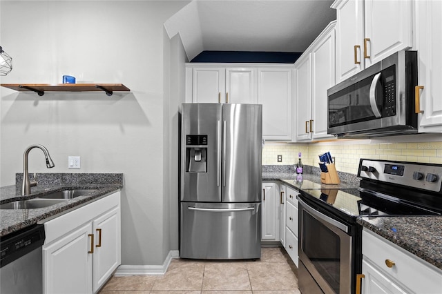 kitchen featuring white cabinetry, appliances with stainless steel finishes, sink, and dark stone countertops