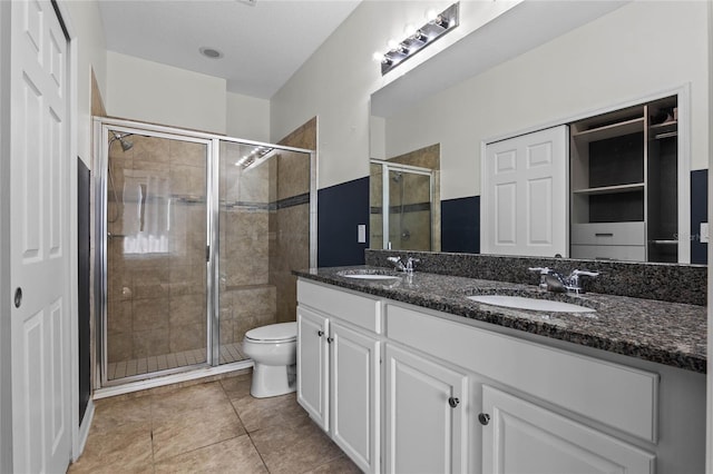 bathroom featuring walk in shower, tile patterned floors, vanity, and toilet