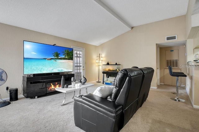 carpeted living room featuring lofted ceiling, a textured ceiling, and a fireplace