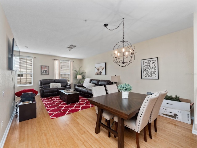 dining space featuring hardwood / wood-style flooring and a chandelier