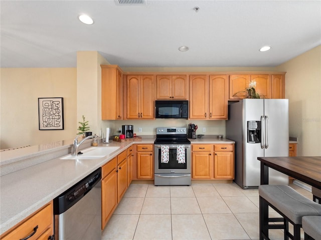 kitchen featuring stainless steel appliances, sink, and light tile patterned floors