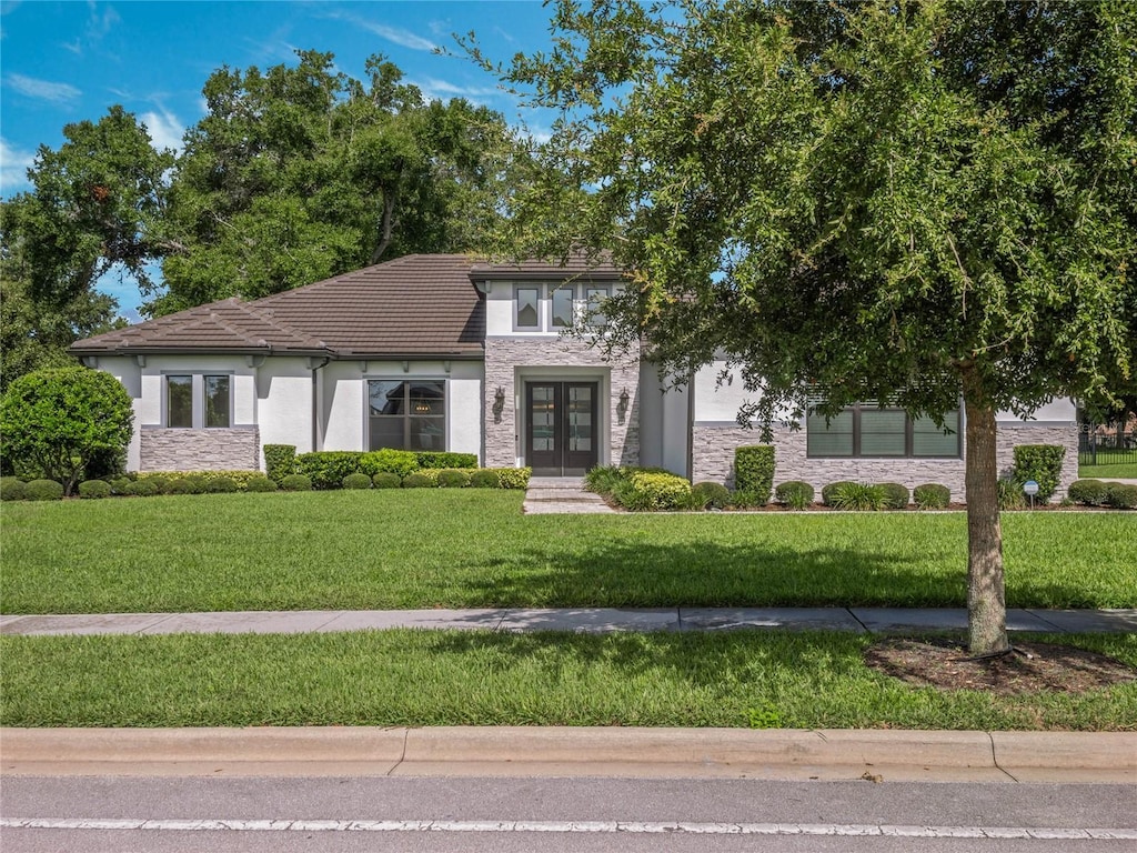 view of front facade with a front yard and french doors