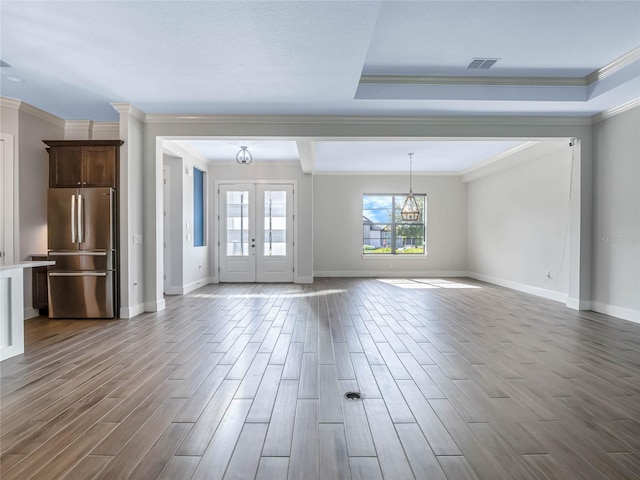 unfurnished living room featuring crown molding, dark hardwood / wood-style floors, a notable chandelier, and french doors