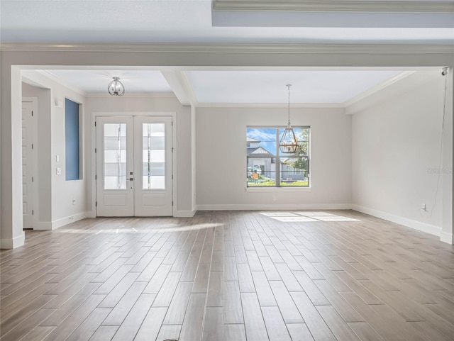 interior space with ornamental molding, an inviting chandelier, light wood-type flooring, and french doors