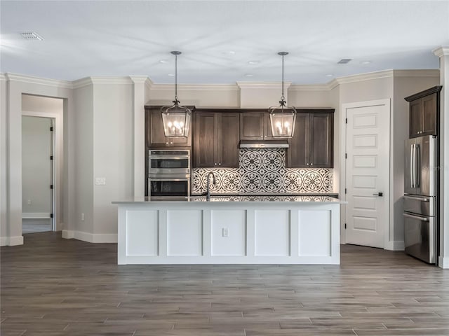 kitchen with a kitchen island with sink, hanging light fixtures, and stainless steel appliances