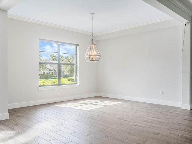 empty room featuring crown molding, a chandelier, and light hardwood / wood-style floors