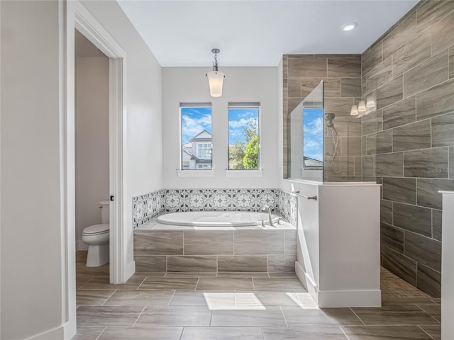 bathroom featuring shower with separate bathtub and toilet