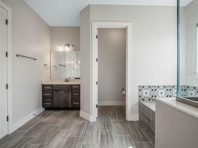 bathroom featuring vanity and tiled bath