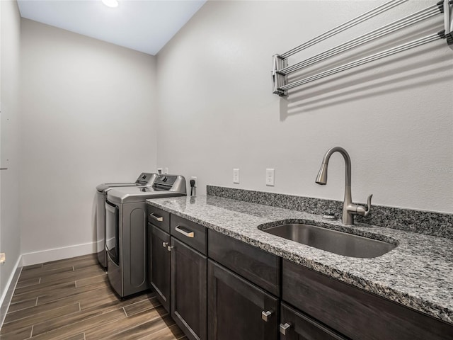 laundry area featuring sink, washing machine and dryer, and cabinets