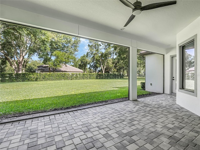 unfurnished sunroom with ceiling fan