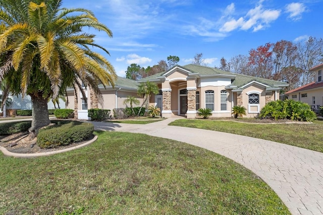 view of front of property with driveway, a front yard, a tiled roof, and stucco siding