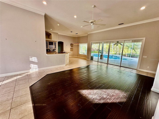 unfurnished living room with light tile patterned floors, baseboards, and ornamental molding