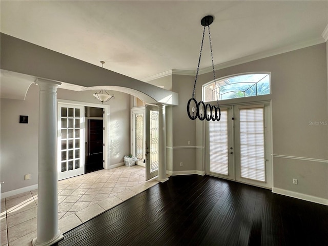 foyer entrance featuring light wood-style flooring, baseboards, french doors, ornate columns, and crown molding