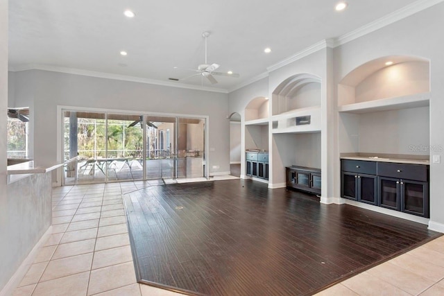 unfurnished living room with built in shelves, crown molding, recessed lighting, light wood-style flooring, and ceiling fan