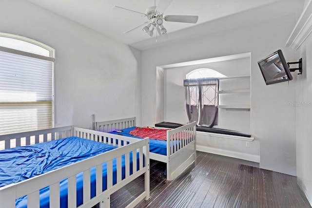 bedroom with dark wood-type flooring, baseboards, and a ceiling fan