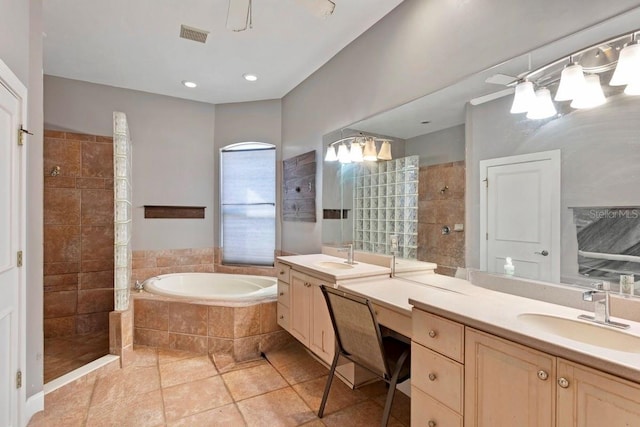 bathroom with visible vents, two vanities, a sink, a walk in shower, and a bath