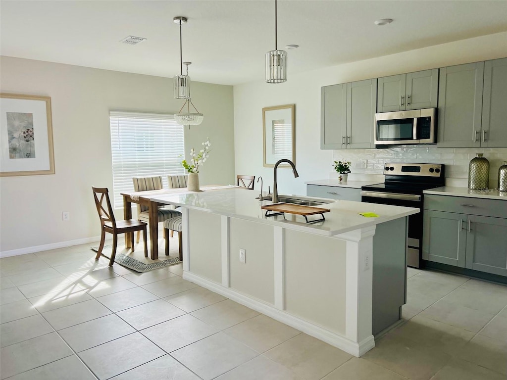 kitchen featuring an island with sink, stainless steel appliances, and sink