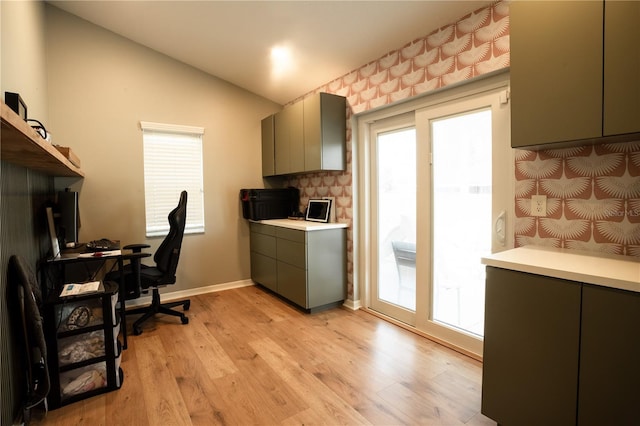 home office with vaulted ceiling and light wood-type flooring