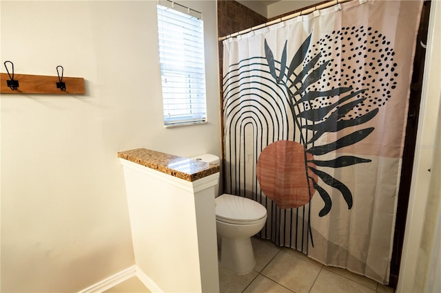 bathroom featuring tile patterned flooring, toilet, and walk in shower