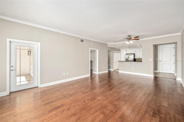 unfurnished living room with ornamental molding, ceiling fan, baseboards, and wood finished floors