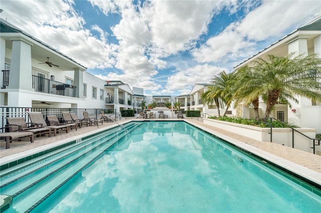 community pool with a residential view, a patio area, and ceiling fan