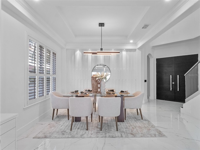 dining room featuring ornamental molding, a notable chandelier, and a tray ceiling