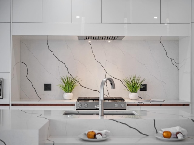 interior details with white cabinetry and light stone countertops