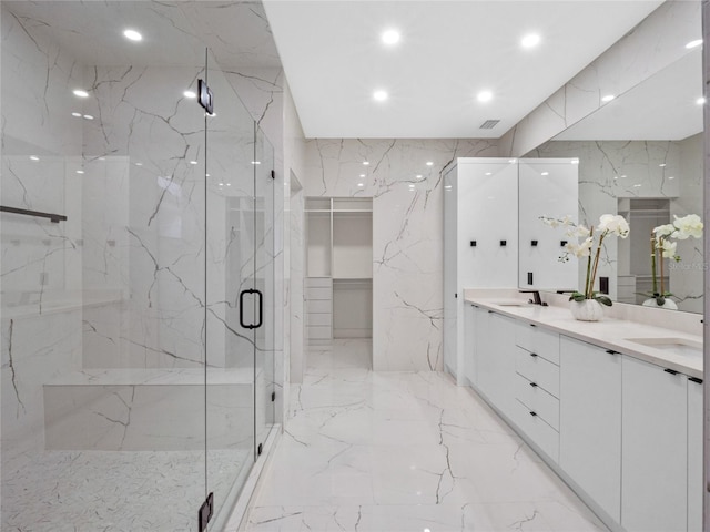 bathroom featuring a shower with door and vanity