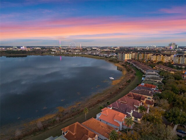 aerial view at dusk featuring a water view