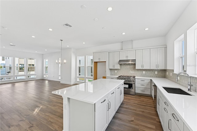 kitchen featuring sink, white cabinetry, a kitchen island, pendant lighting, and stainless steel appliances