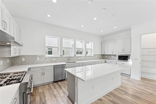 kitchen featuring white cabinetry, stainless steel appliances, sink, and a kitchen island