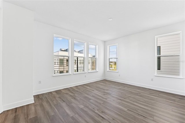 unfurnished room featuring hardwood / wood-style flooring and a healthy amount of sunlight