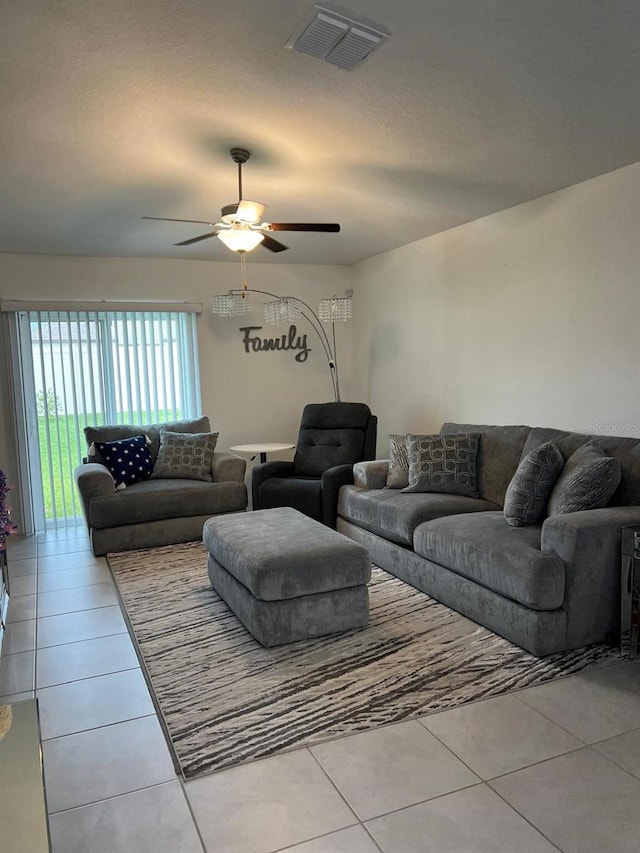 tiled living room featuring ceiling fan and a textured ceiling