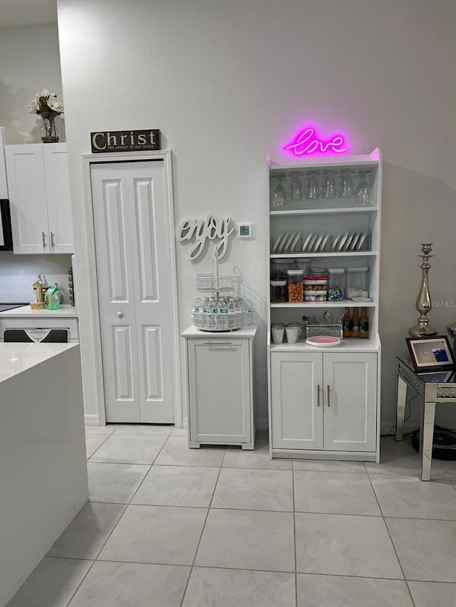 bar featuring white cabinetry and light tile patterned floors