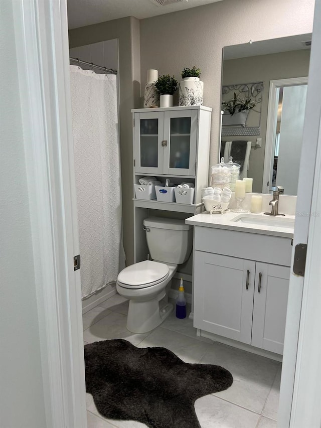 bathroom featuring vanity, tile patterned floors, and toilet