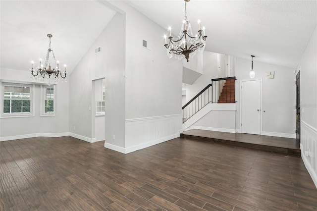 unfurnished living room with an inviting chandelier, high vaulted ceiling, and dark wood-type flooring