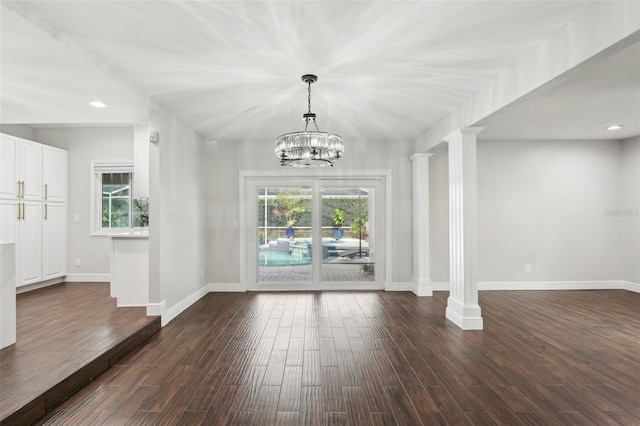 unfurnished dining area featuring ornate columns, dark hardwood / wood-style flooring, and a healthy amount of sunlight