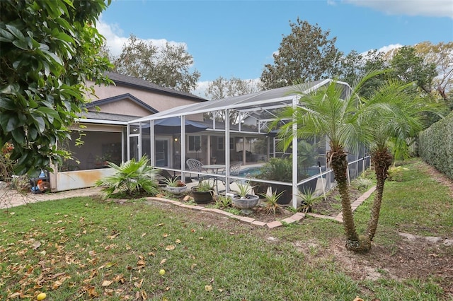 view of side of property featuring glass enclosure and a lawn