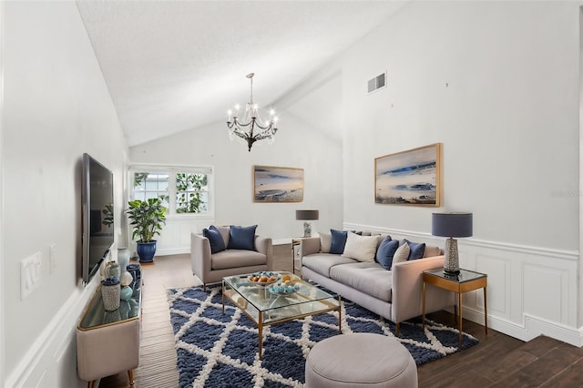 living room featuring dark hardwood / wood-style flooring, high vaulted ceiling, and a chandelier