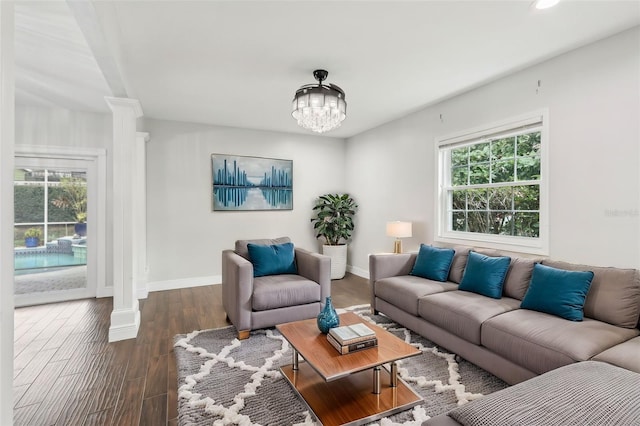 living room featuring decorative columns, dark hardwood / wood-style flooring, and a wealth of natural light