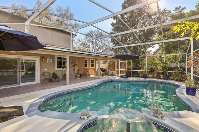 view of pool with glass enclosure and a patio area