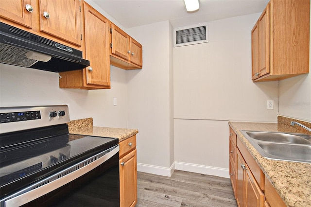 kitchen featuring sink, range with electric cooktop, and light hardwood / wood-style floors