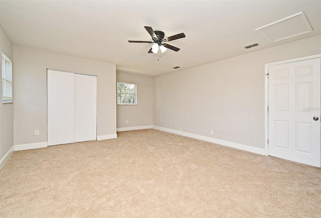 unfurnished bedroom with ceiling fan, a closet, and light carpet