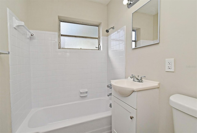 full bathroom with vanity, tiled shower / bath, and toilet