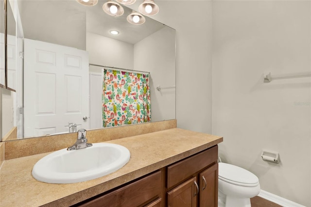 bathroom featuring vanity, walk in shower, and toilet