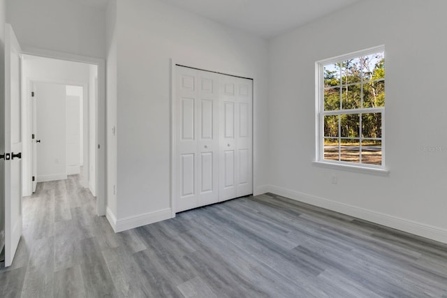 unfurnished bedroom featuring light hardwood / wood-style flooring and a closet