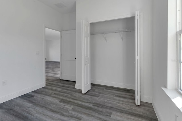 unfurnished bedroom featuring dark hardwood / wood-style flooring and a closet